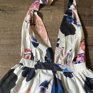 L’astite by Amy white floral romper. It has a tie neck and open back